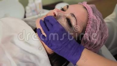 戴着手套的手从女人脸上摘下`面具。 治疗后<strong>皮肤发红</strong>，刺激。 特写